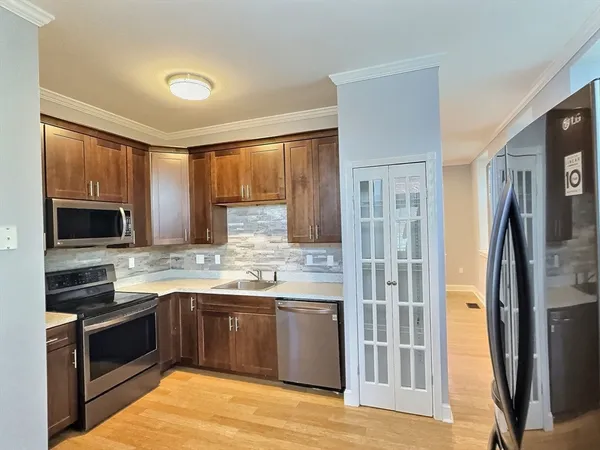 a kitchen with stainless steel appliances granite countertop a stove a sink and a refrigerator