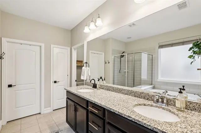 a bathroom with a granite countertop sink a mirror and a shower