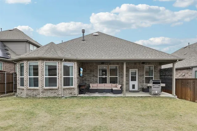a view of a house with large windows and a table and chairs