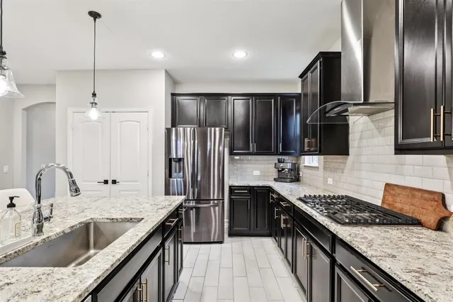 a kitchen with stainless steel appliances granite countertop a sink stove and refrigerator