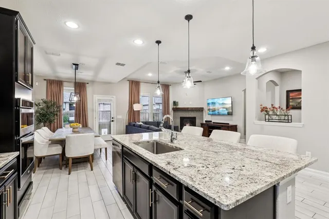 a kitchen with granite countertop a table chairs stove and wooden floor
