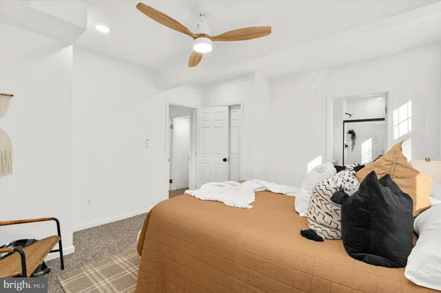 a bedroom with a large bed and wooden floor