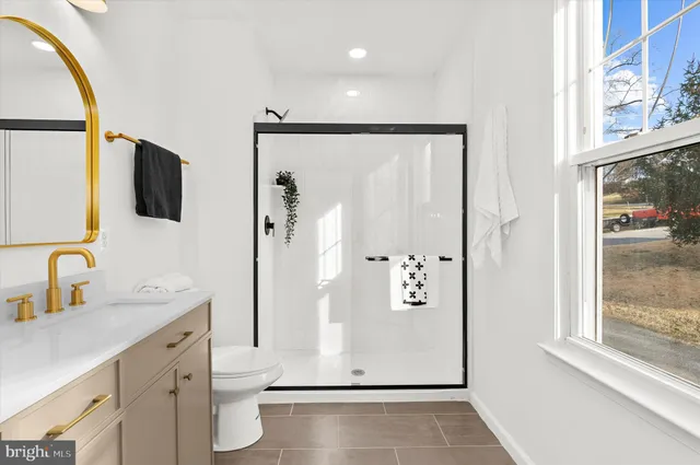 a bathroom with a double vanity sink toilet and shower