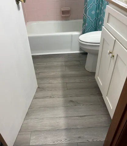 a bathroom with a white toilet and bathtub