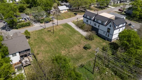 an aerial view of residential houses with outdoor space and trees