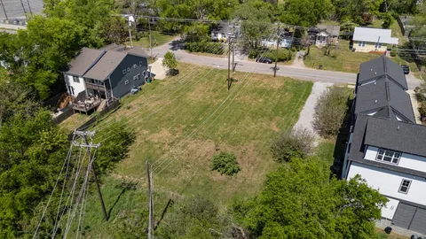 an aerial view of residential houses with outdoor space and trees