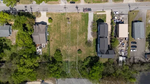 an aerial view of residential houses with outdoor space and parking