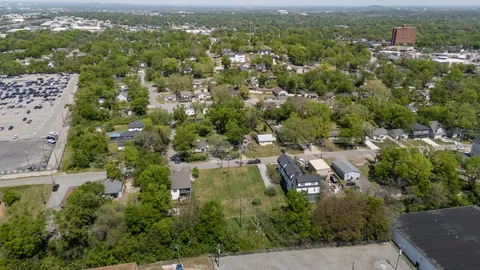 an aerial view of residential houses with outdoor space and trees