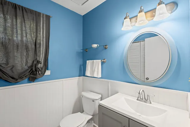 a bathroom with a toilet a sink and a mirror