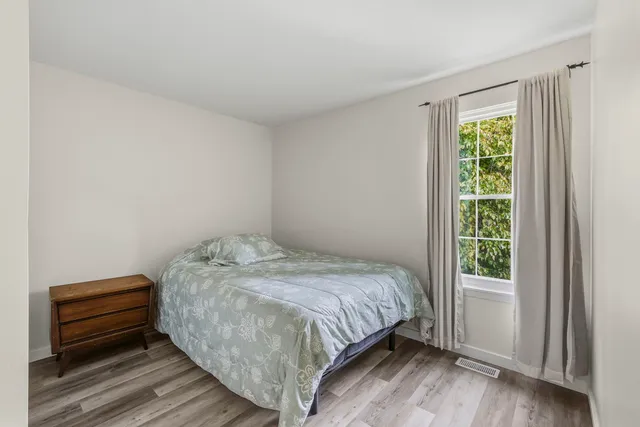 a bed sitting in a bedroom next to a window