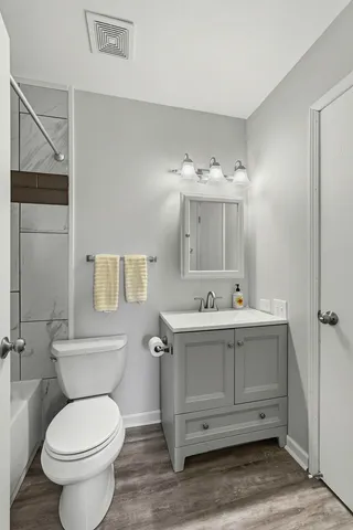 a bathroom with a granite countertop toilet sink and mirror