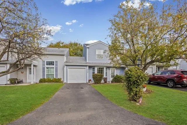 a front view of a house with a garden and trees