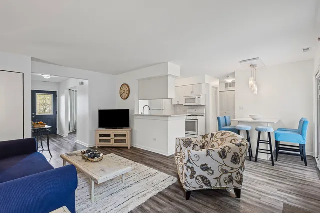 a living room with furniture a dining table and chairs with wooden floor
