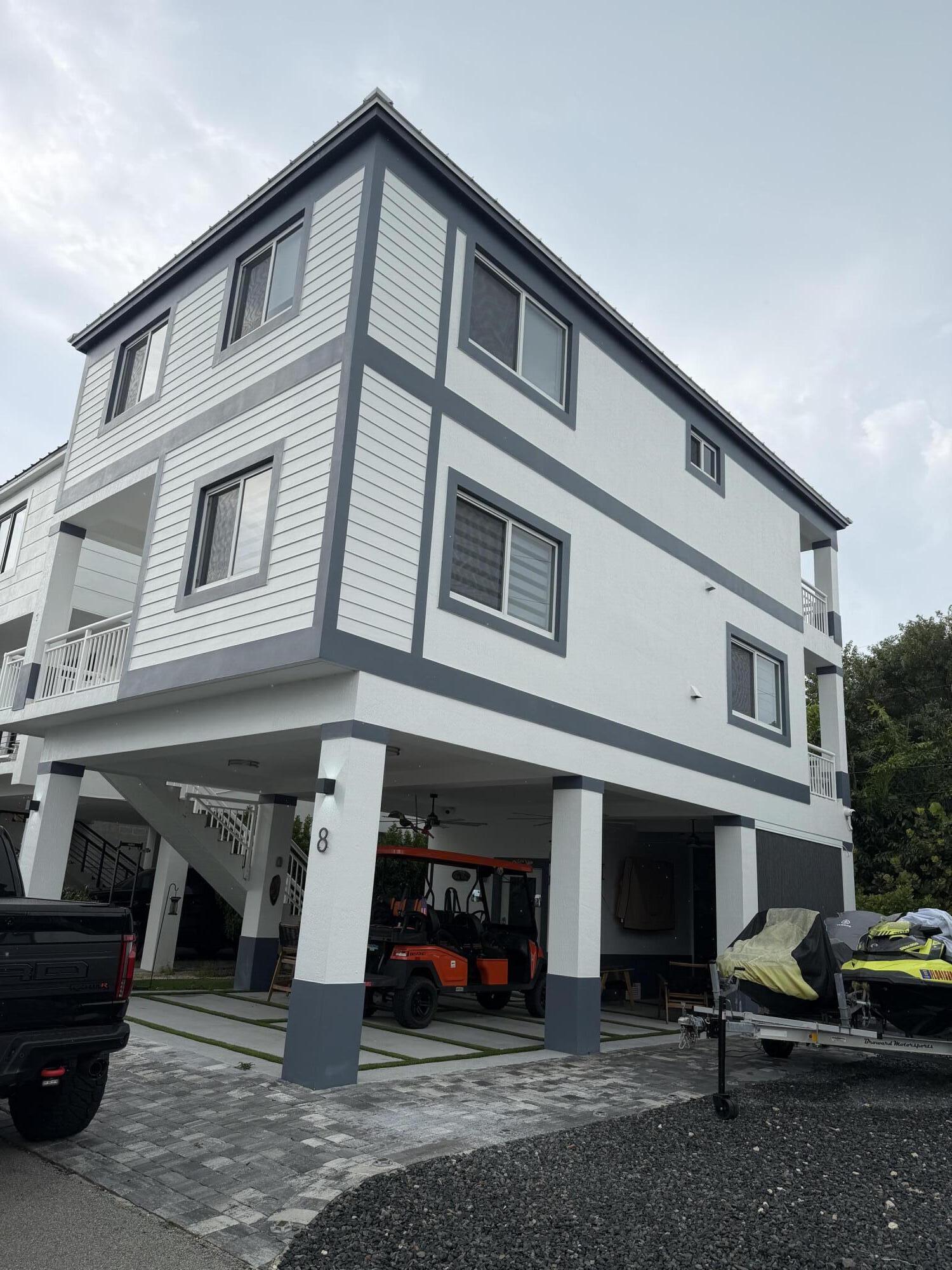 94825 Overseas Highway, Unit 8 Key Largo, FL 33037 - Photo 1 of 12 a front view of building with multiple windows