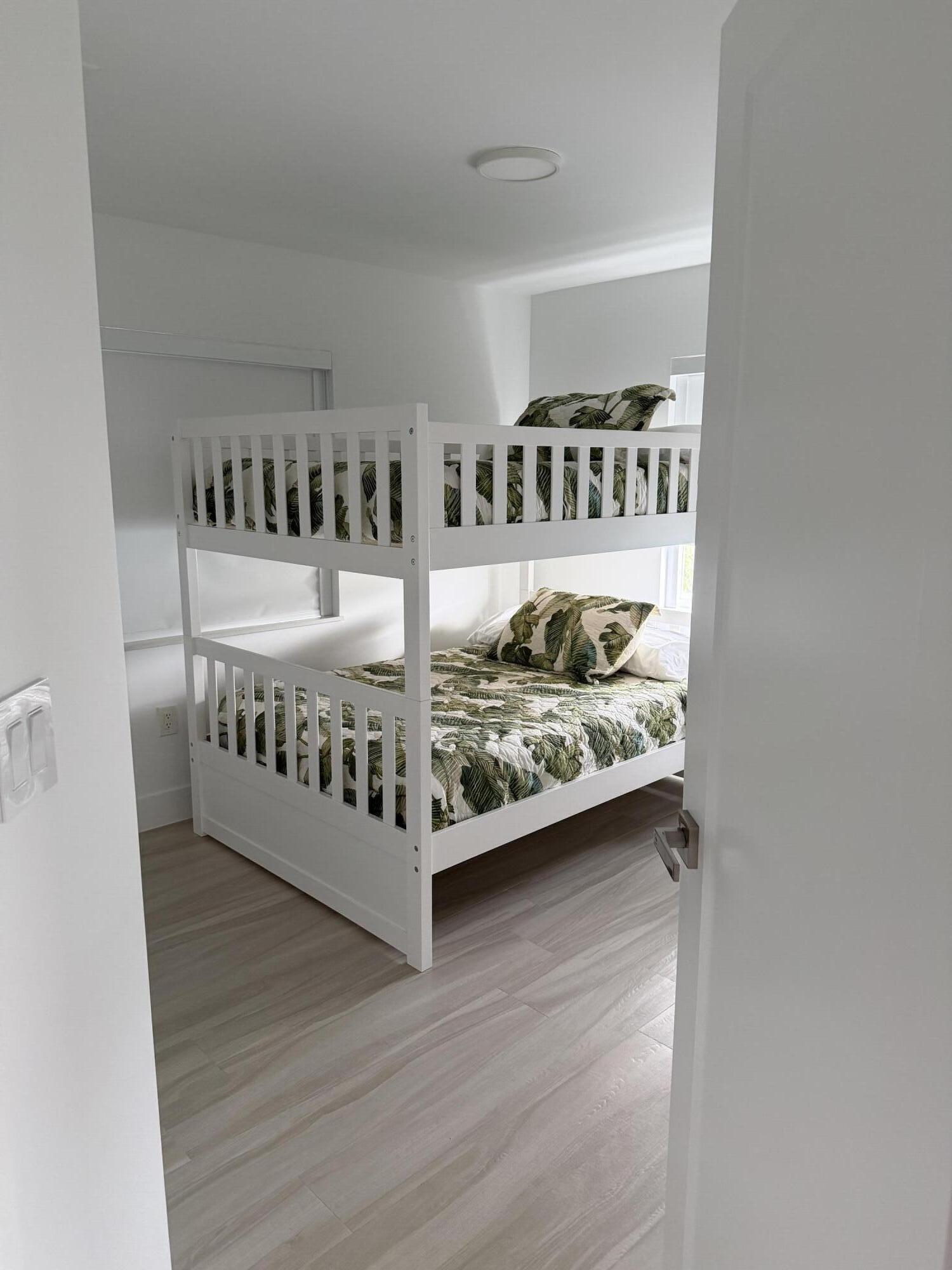 94825 Overseas Highway, Unit 8 Key Largo, FL 33037 - Photo 7 of 12 a view of a bedroom with wooden floor