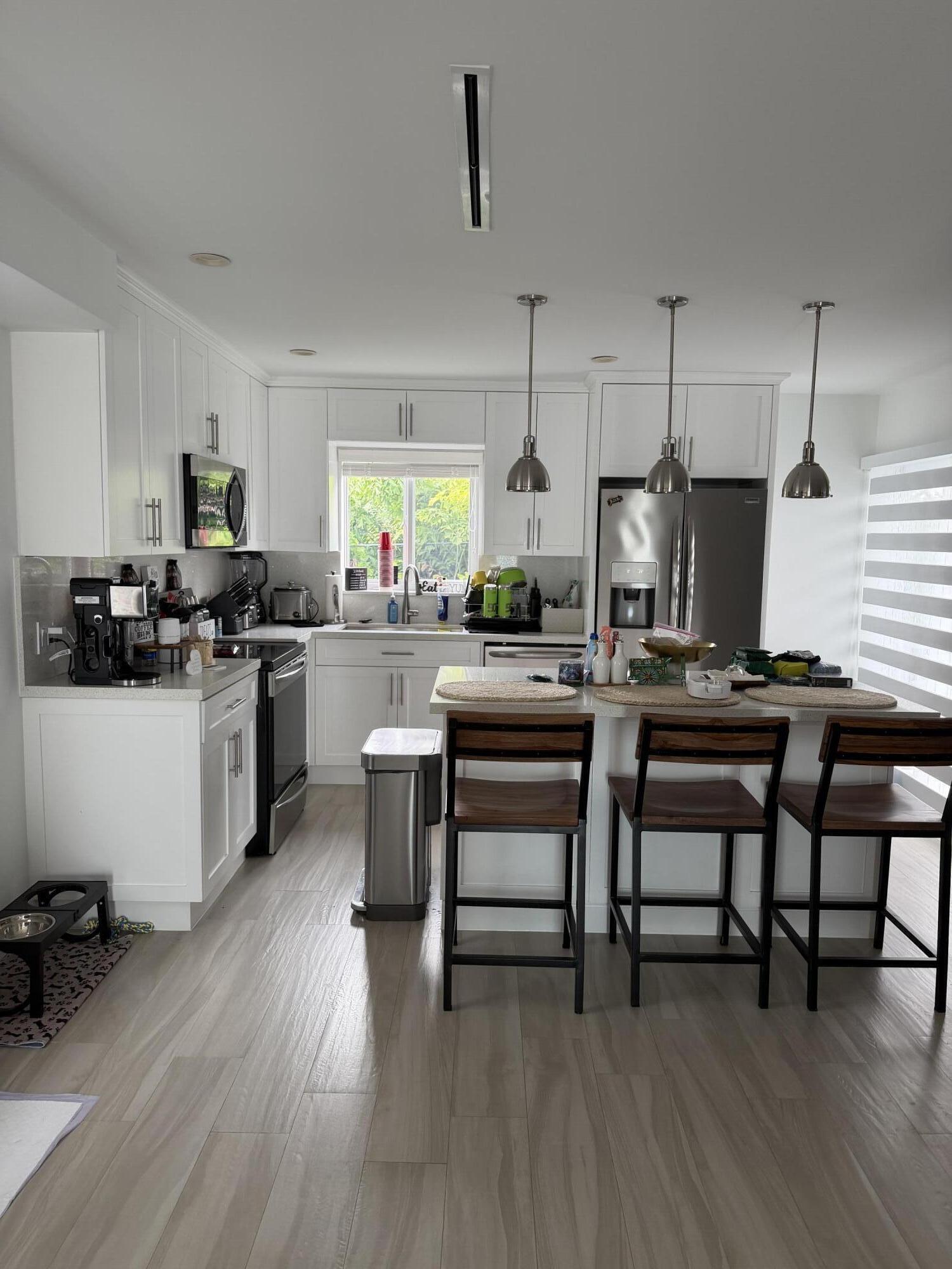 94825 Overseas Highway, Unit 8 Key Largo, FL 33037 - Photo 9 of 12 a kitchen with sink cabinets and wooden floor