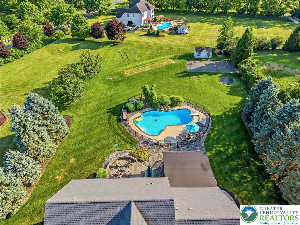 13 Country Road Northampton, PA 18067 - Photo 4 of 71 An aerial perspective reveals a vast estate with multiple pools, a sports court, and a cozy fire pit area.
