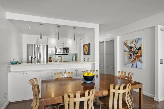 a dining table with chairs and painting on the wall