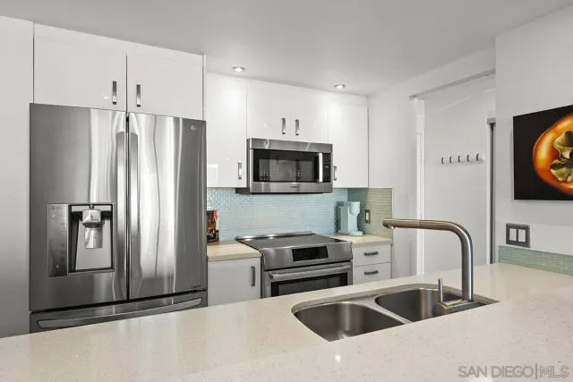 a kitchen with stainless steel appliances a refrigerator sink and microwave