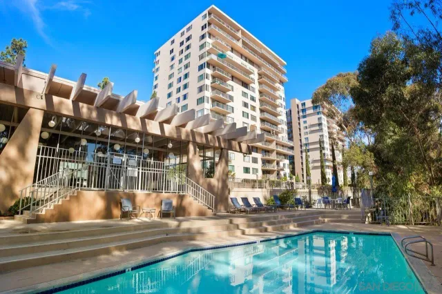 a view of a tall building next to a yard