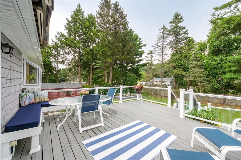 83 Loomis Drive Chicopee, MA 01020 - Photo 31 of 40 a view of a patio with a dining table and chairs with wooden floor and fence