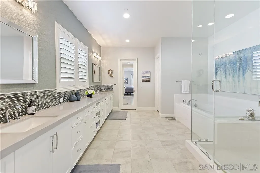 4702 Crespi Court Carlsbad, CA 92010 - Photo 21 of 39 a large white bathroom with a granite countertop sink mirror and a bathtub