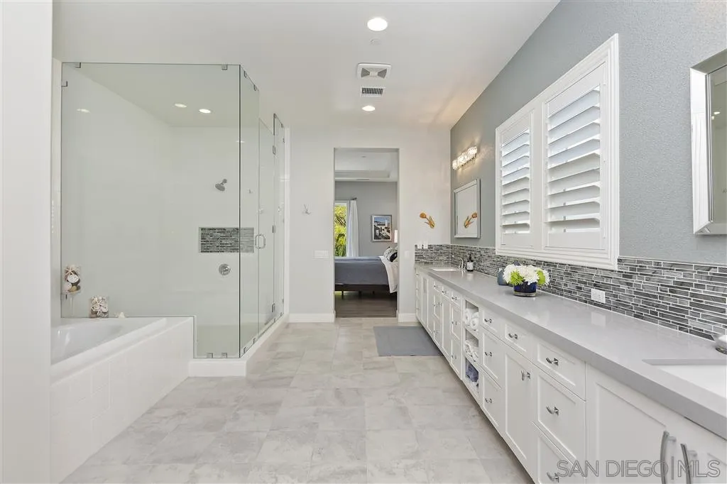 4702 Crespi Court Carlsbad, CA 92010 - Photo 22 of 39 a bathroom with a double vanity sink and a bathtub