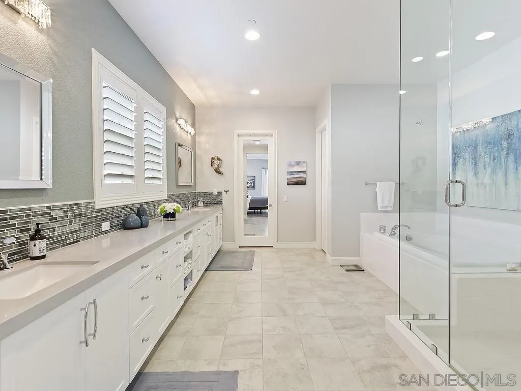 4702 Crespi Court Carlsbad, CA 92010 - Photo 23 of 39 a large white bathroom with a granite countertop sink mirror and a shower