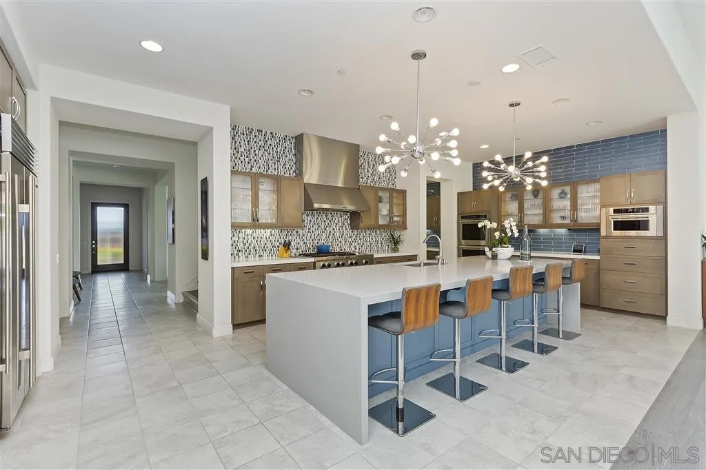 4702 Crespi Court Carlsbad, CA 92010 - Photo 6 of 39 a kitchen with granite countertop a counter space dining table and stainless steel appliances