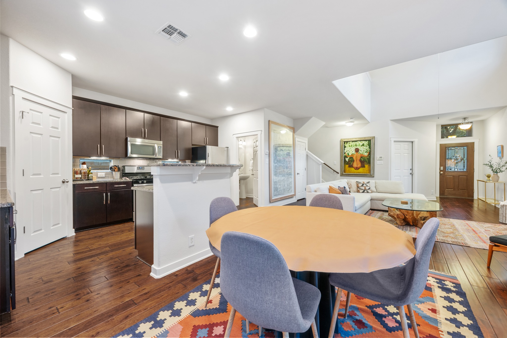 2101 Rivers Edge Way, Unit 19 Austin, TX 78741 - Photo 10 of 24 a kitchen with stainless steel appliances kitchen island granite countertop a dining table chairs refrigerator sink and cabinets