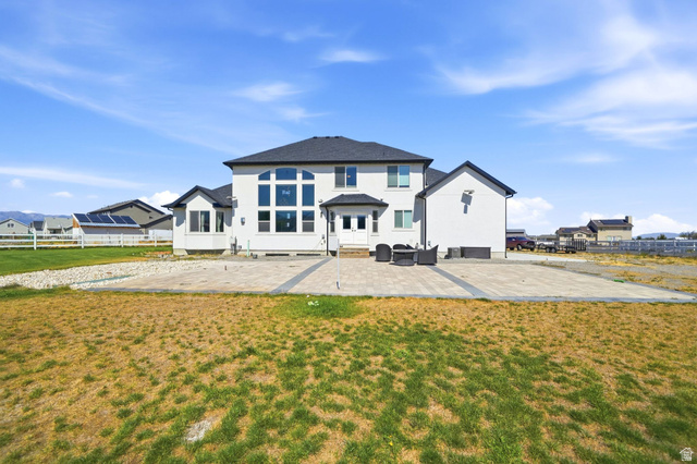 3644 Spiral Springs Road Tooele, UT 84074 - Photo 32 of 41 Modern stucco exterior with a dark shingle roof and a spacious paver patio