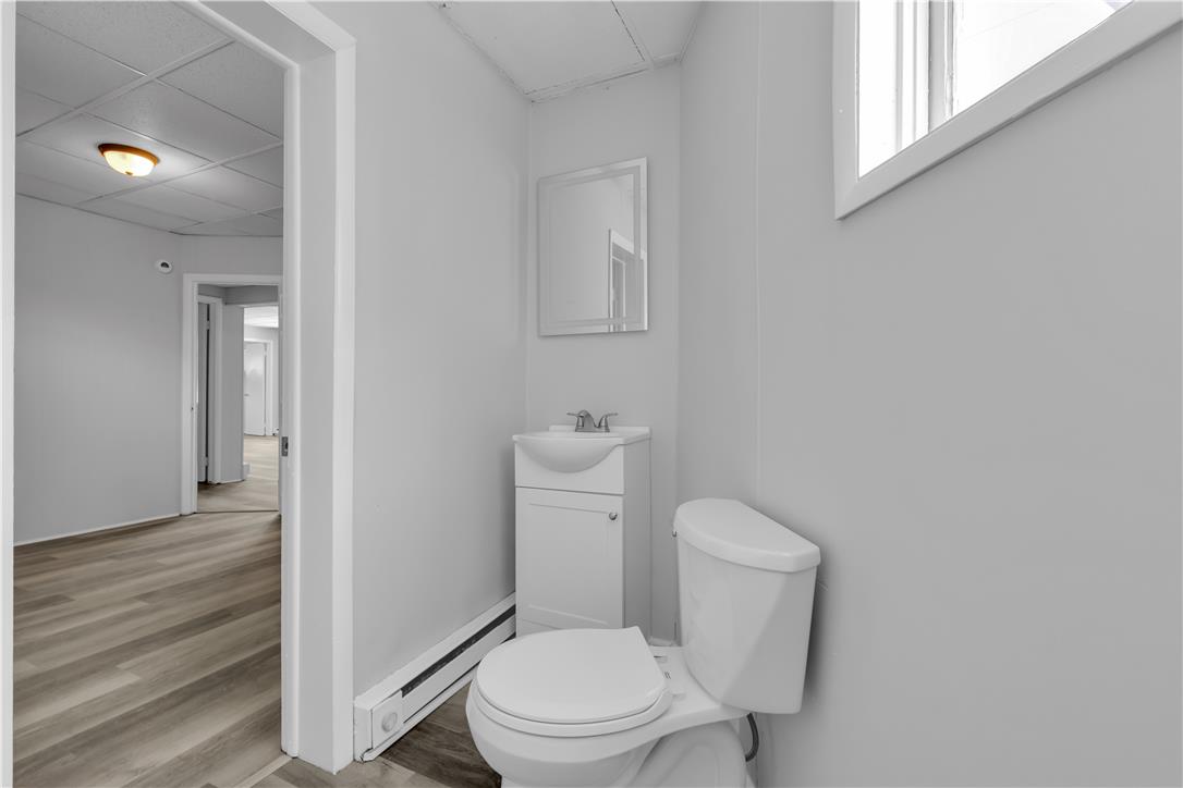 149 West Ridge Street, Unit 2A Lansford, PA 18232 - Photo 4 of 14 A compact half bath features neutral walls and wood-look flooring adjacent to a hallway.