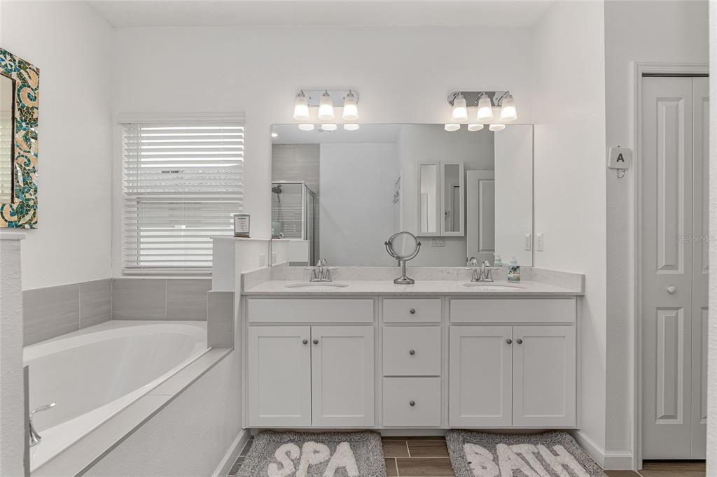 5688 Southwest 92nd Place Ocala, FL 34476 - Photo 31 of 54 a bathroom with a sink double vanity granite tub and a mirror