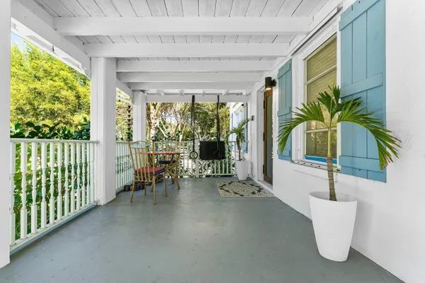 a view of a porch with chairs and floor to ceiling window