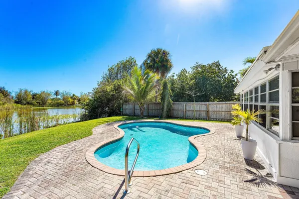 a view of a swimming pool with a patio and a yard