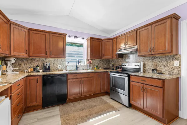 a kitchen with stainless steel appliances granite countertop a stove sink and cabinets
