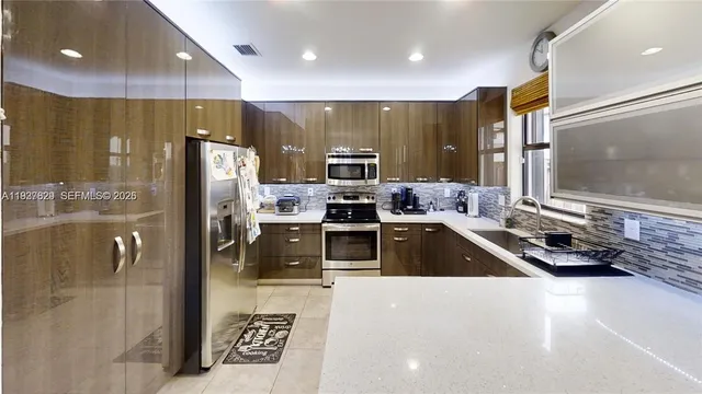 a kitchen with stainless steel appliances a refrigerator a stove a sink and a oven with wooden floor