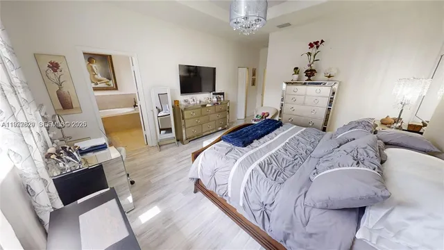 a bedroom with a bed and flat tv screen on the dresser
