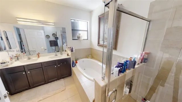 a bathroom with a tub sink mirror and a shower