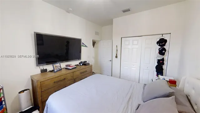 a bedroom with a bed and a flat screen tv