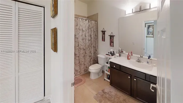 a bathroom with a double vanity sink toilet mirror and shower