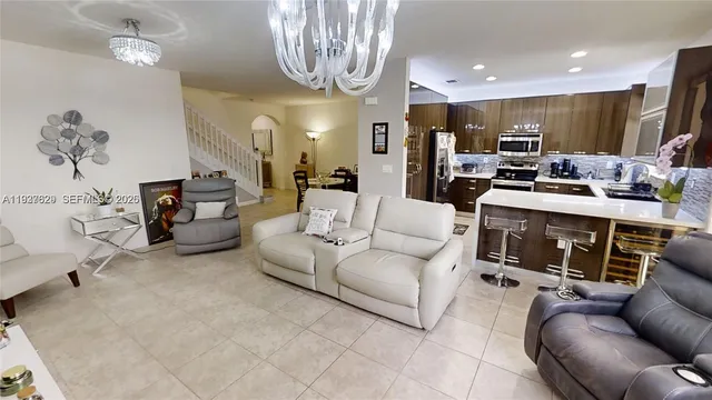 a living room with furniture gym equipment and a chandelier
