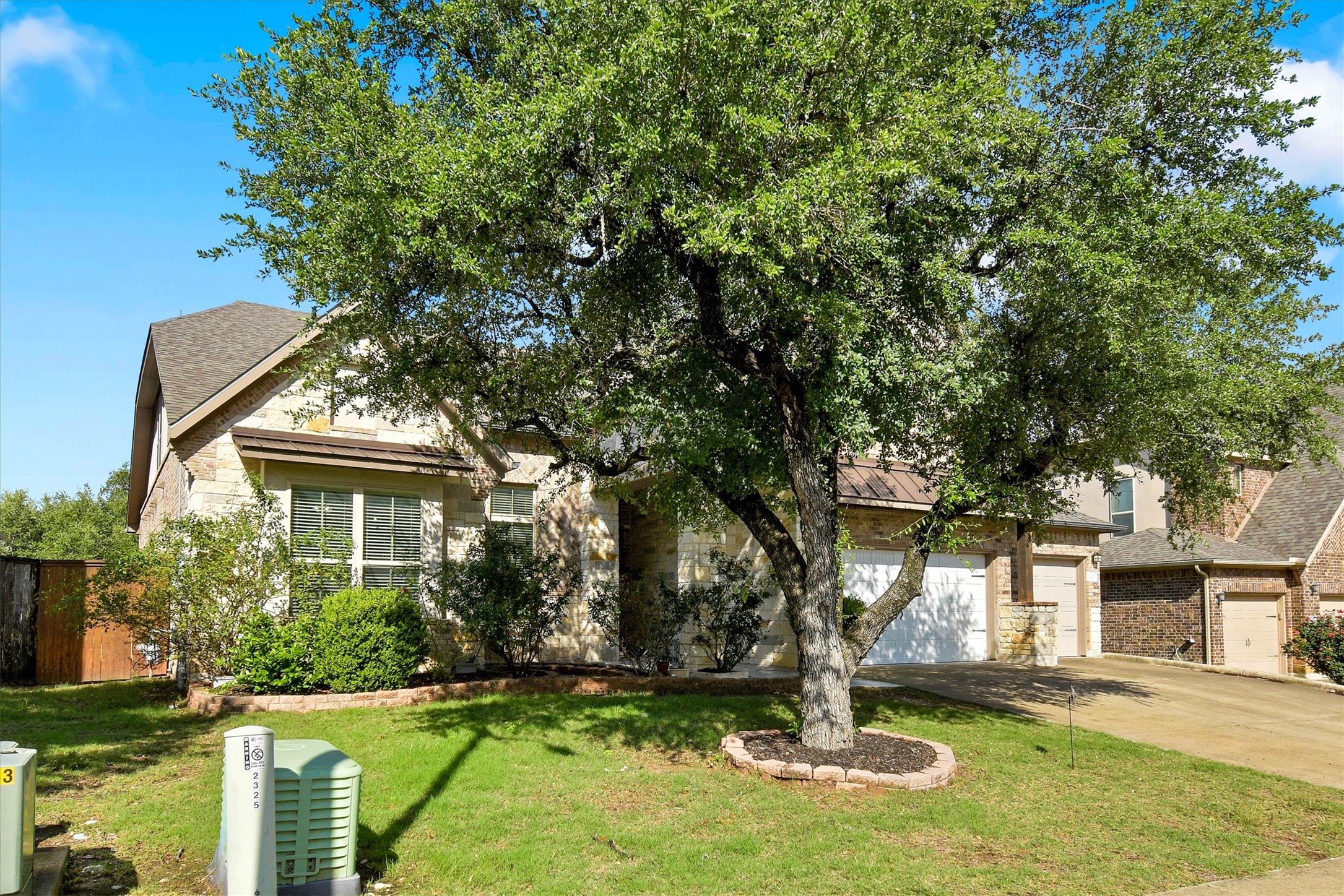 2325 Blended Tree Ranch Drive Leander, TX 78641 - Photo 4 of 35 Mature trees enhance the curb appeal of this charming stone-accented residence.