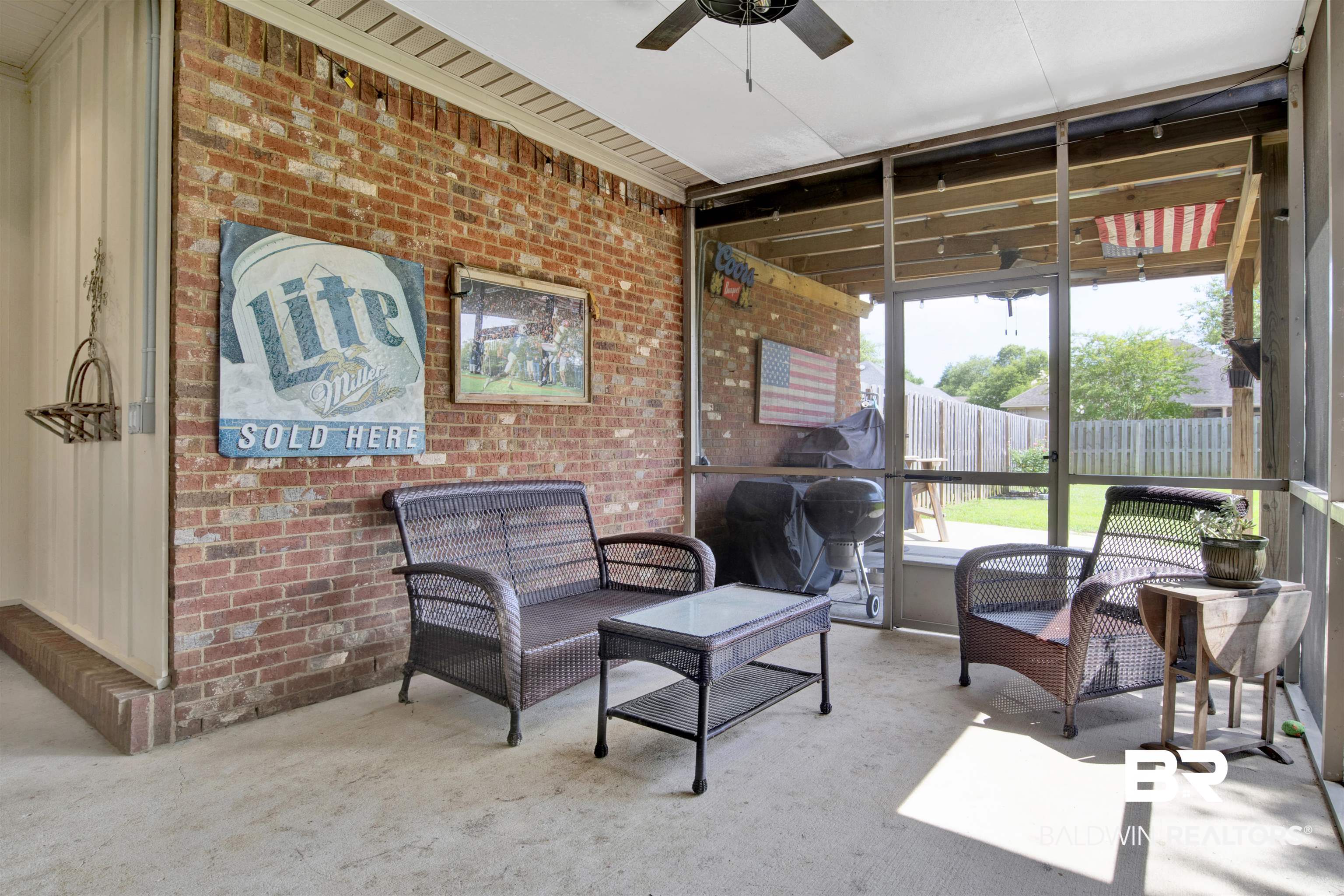 10368 Gayfer Rd Extension Fairhope, AL 36532 - Photo 30 of 43 Screened porch featuring a brick accent wall, concrete flooring, and a ceiling fan