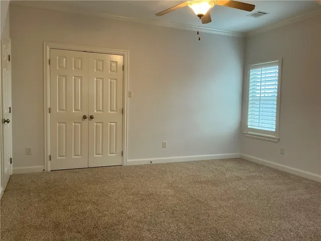 an empty room with windows and fan