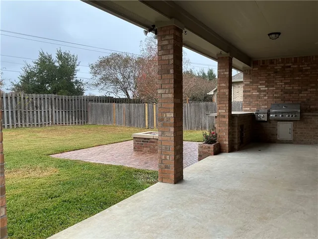 a view of a backyard with a floor to ceiling window and fence