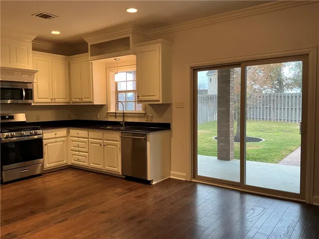 a kitchen with granite countertop a stove a sink and a granite counter top