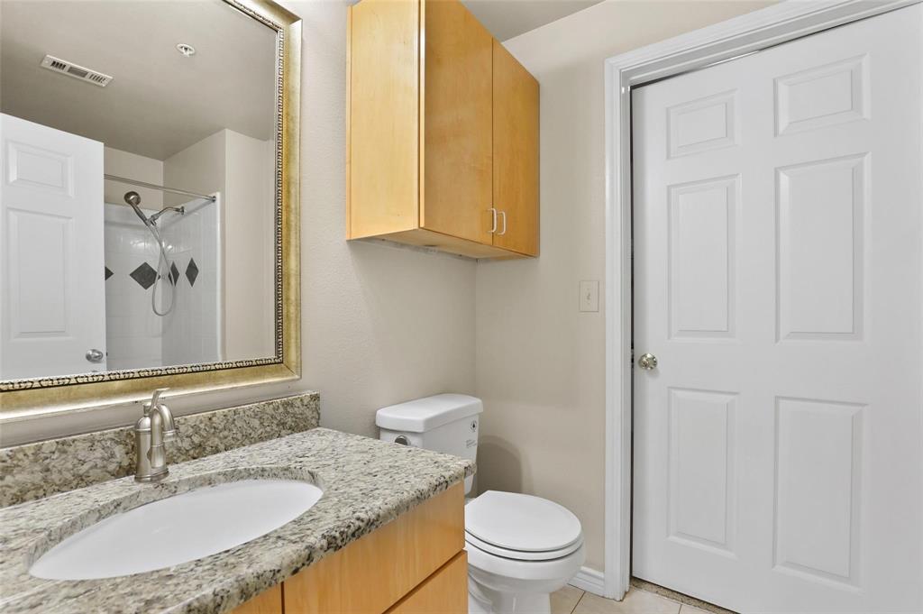 3102 Kings Road, Unit 1303 Dallas, TX 75219 - Photo 12 of 25 a bathroom with a granite countertop sink toilet and a mirror