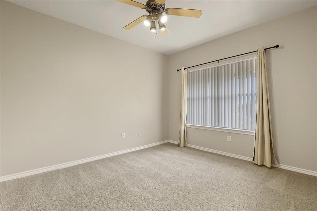3102 Kings Road, Unit 1303 Dallas, TX 75219 - Photo 14 of 25 an empty room with a ceiling fan and windows