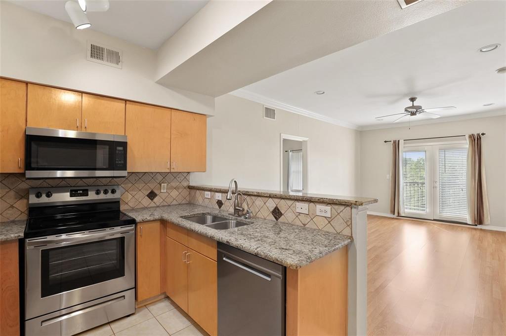 3102 Kings Road, Unit 1303 Dallas, TX 75219 - Photo 2 of 25 a kitchen with granite countertop a sink and a stove top oven